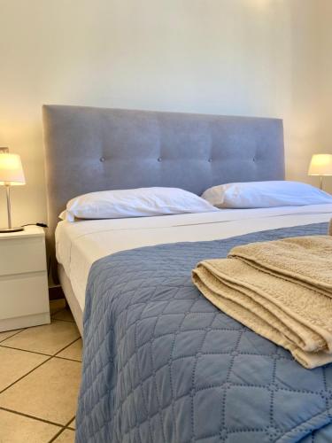 a bedroom with a large bed with a blue headboard at Casa di Sara in Stiava