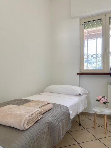 a white bedroom with a bed and a window at Casa di Sara in Stiava
