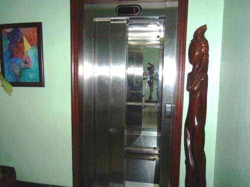 a metal elevator in a room with a statue at Hotel Discovery in Santo Domingo