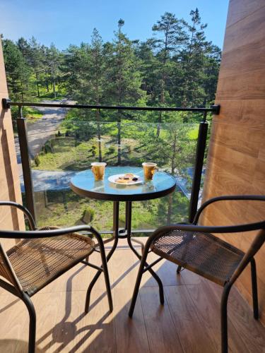 un tavolo e due sedie su un balcone con vista di Apartman Planinski san Divčibare a Divčibare