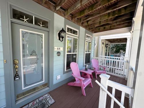 a porch with pink chairs and a table at Sunset Island - 35 Seaside in Ocean City
