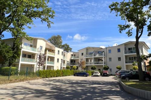 an apartment complex with cars parked in a parking lot at Ferienwohnung Dünenhopser in Rostock