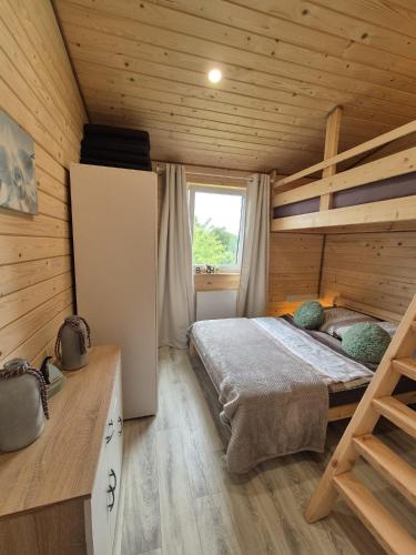 a bedroom with a bed in a wooden cabin at Domus Mare Tiny House 2 in Wisełka