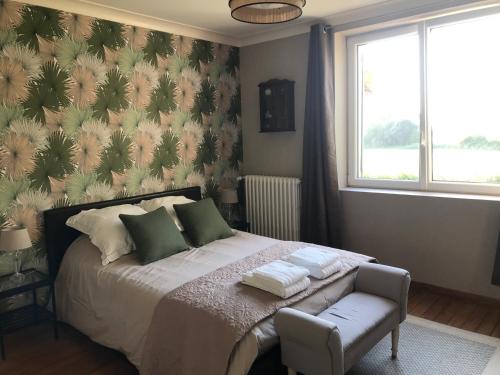 une chambre avec un lit, une chaise et une fenêtre dans l'établissement Chambres d'hôtes de la baie, à Sallenelles