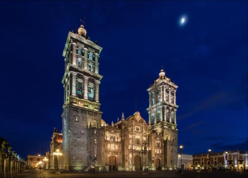 a large building with a clock tower at night at Gran Hotel de Puebla by HNF in Puebla
