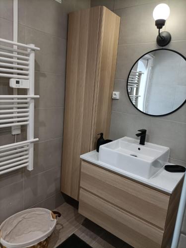 une salle de bain avec un lavabo blanc et un miroir dans l'établissement Vue apaisante montagnes, plage 5 minutes à pied, à Banyuls-sur-Mer