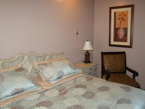 a bedroom with a bed and a chair and a dresser at King's Motel & Restaurant in St. Paul