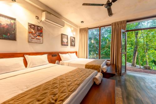 a hotel room with two beds and a window at Trance rabara resort in Avissawella