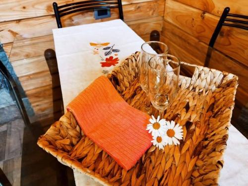 a basket with wine glasses and flowers on a table at Cabaña Entre Arrayanes 3 habitaciones in Puerto Montt