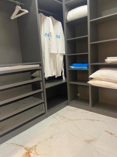 a walk in closet with gray walls and shelves at F&L Relax Mamaia Nord -Apartament cu parcare gratuită in Mamaia Sat/Năvodari