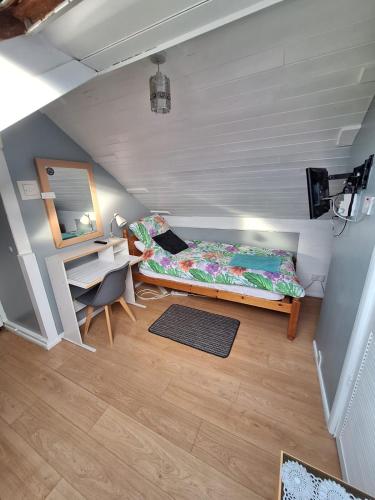 a bedroom with a bed and a desk and a mirror at Harrow B & B in Harrow Weald