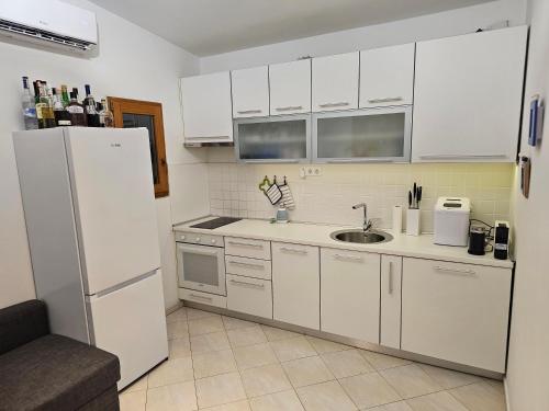 a kitchen with white cabinets and a white refrigerator at Villa Jana in Kolan