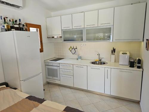 a kitchen with white cabinets and a white refrigerator at Villa Jana in Kolan