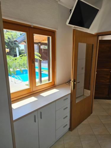 a kitchen with white cabinets and a window and a television at Villa Jana in Kolan