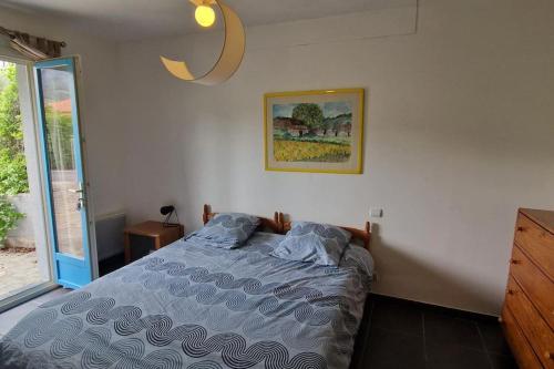une chambre avec un lit et un tableau au mur dans l'établissement Duplex La maison bleue, à Collioure
