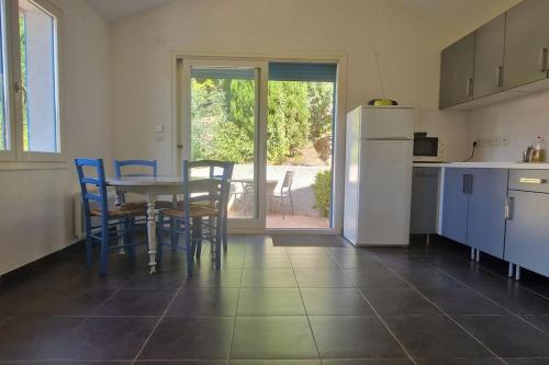 une cuisine avec une table, des chaises et un réfrigérateur dans l'établissement Duplex La maison bleue, à Collioure