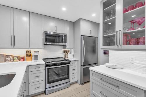 ネープルズにあるCompletely renovated first floor condoの白いキャビネットとステンレス製の電化製品を備えたキッチン