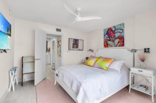 ネープルズにあるCompletely renovated first floor condoの白いベッドとカラフルな枕のある寝室