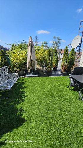 a patio with a lawn with an umbrella and chairs at Casa Luca in Grimbergen