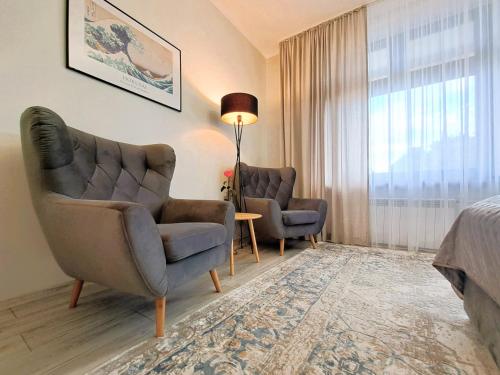 a hotel room with two chairs and a bed at Tullu Apartament - w centrum, blisko bulwaru, blisko molo in Ostróda