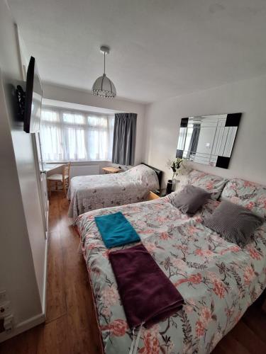 a bedroom with two beds and a living room at Harrow B & B in Harrow Weald