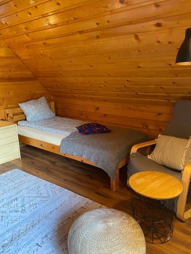 a room with a bed and a couch in a cabin at Babie Domki in Zawoja