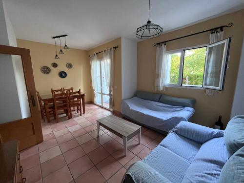 a living room with a couch and a table at Adosado con jardín Urb Galia Ballena in Cádiz