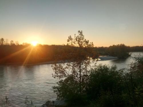 a sunset over a river with the sun setting at B&B Ca' Nobil in Bernate Ticino