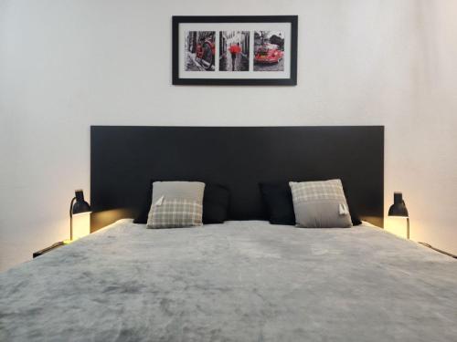 a bedroom with a large bed with two lamps at Apart Hotel Montevideo in Montevideo