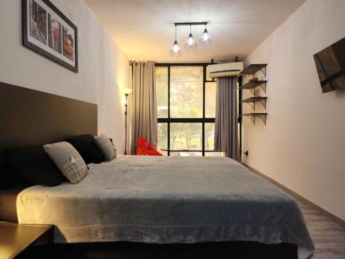 a bedroom with a large bed and a window at Apart Hotel Montevideo in Montevideo