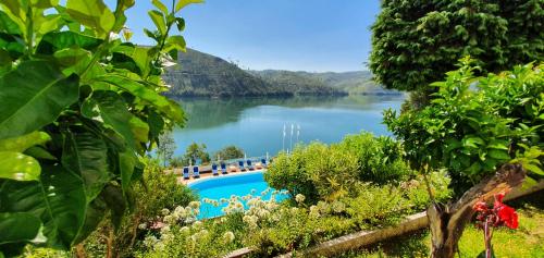 a view of a lake with a swimming pool at Lago Azul Eco Hotel in Ferreira do Zêzere