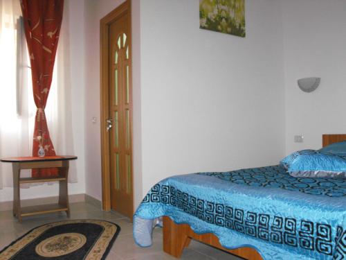 a bedroom with a bed and a table and a window at Casa Rustica in Focşani