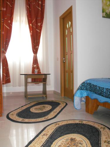 a room with two rugs and a table and a door at Casa Rustica in Focşani