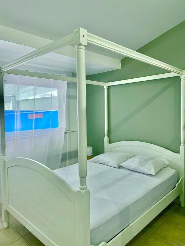 une chambre avec un lit blanc à baldaquin dans l'établissement Villa Felin Feline, à LʼIsle-sur-la-Sorgue