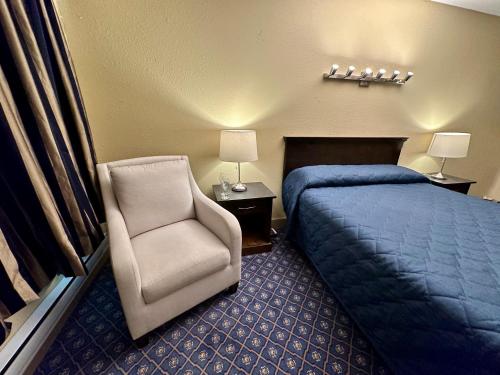 a hotel room with a bed and a chair at Linda Vista Motel in Surrey