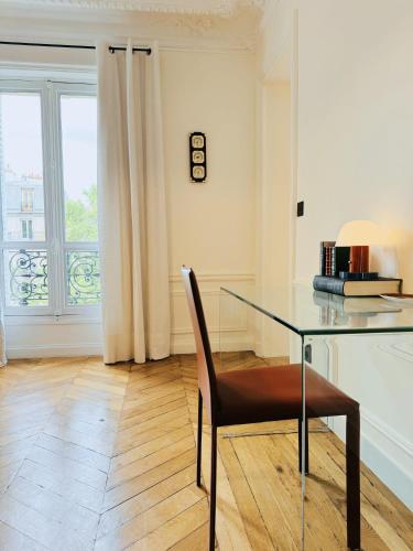 une salle à manger avec une table en verre et une chaise dans l'établissement 3 bedrooms in Marais, à Paris