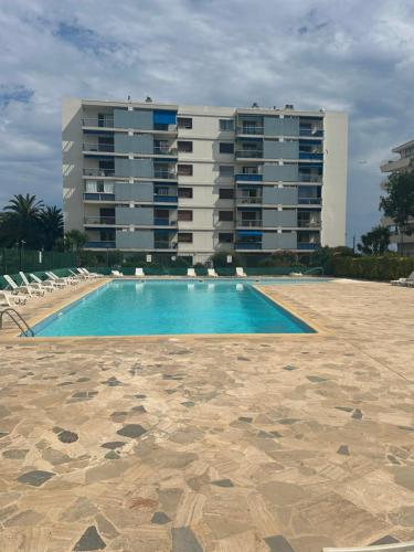 une piscine en face d'un grand bâtiment dans l'établissement Splendide vue panoramique sur la Méditerranée, à Cagnes-sur-Mer