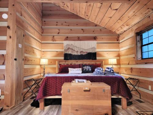 a bedroom with a bed in a wooden room at Romantic, Private Cabin in Smokies Hot Tub Firepit in Sevierville