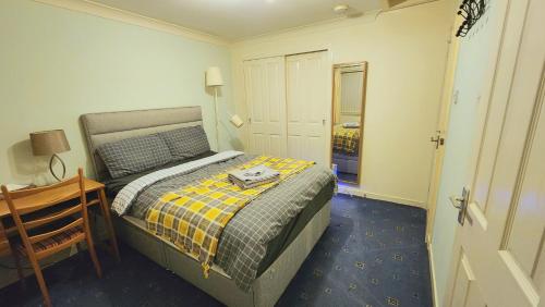 a bedroom with a bed and a table and a mirror at Lovely Home Stay 2 in Fife