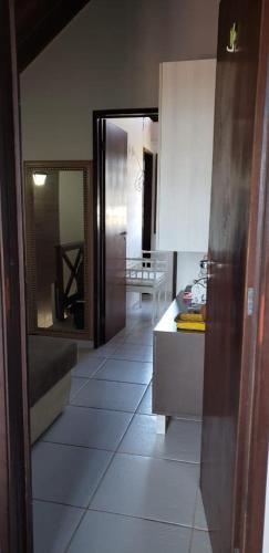 a kitchen with white tile floors and a mirror at Chalé Nevada 310 in Bananeiras