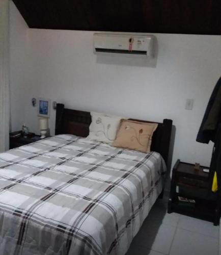 a bedroom with a bed with a striped comforter at Chalé Nevada 310 in Bananeiras