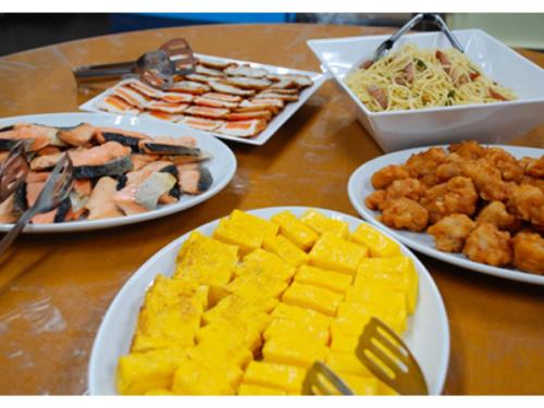 a wooden table with plates of food on it at Sun Hotel Kokubu - Vacation STAY 62468v in Kirishima