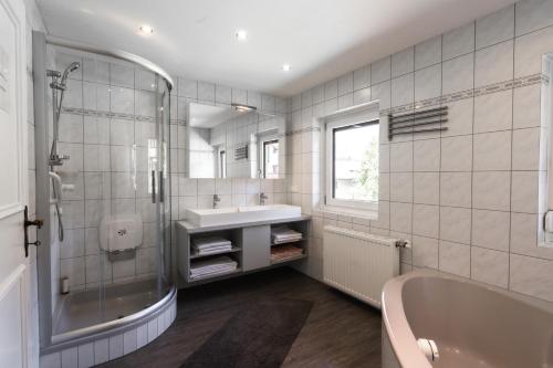 a white bathroom with a tub and a sink at Ferienhaus Erika in Seefeld in Tirol