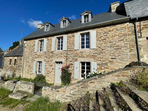 Cette ancienne maison en pierre est dotée de portes et de fenêtres blanches. dans l'établissement Maison de charme dans le site classé de Brélévenez, à Lannion