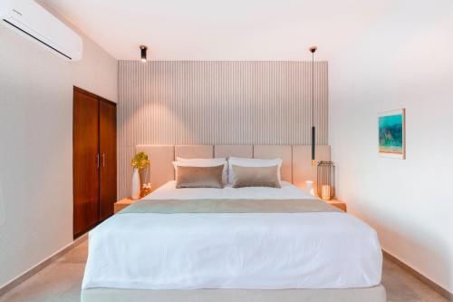 a bedroom with a large white bed with two pillows at Areia Boutique Hotel - Puerto Morelos in Puerto Morelos