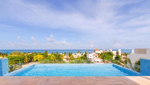 a swimming pool with a view of the ocean at Areia Boutique Hotel - Puerto Morelos in Puerto Morelos