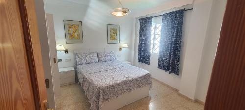 a small bedroom with a bed and a window at UF holiday Villa in Málaga