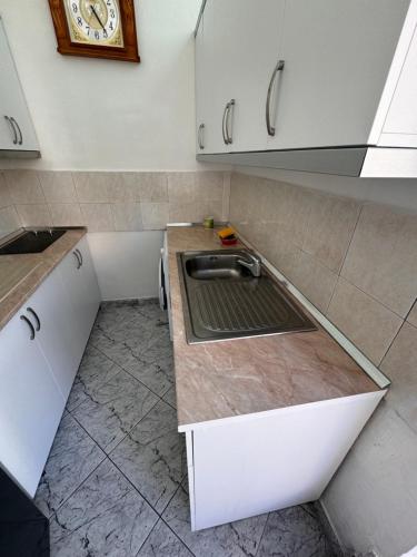 una cucina con un lavandino e un orologio a parete di Vila Victor a Vlorë