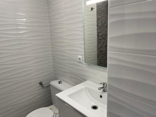 ein weißes Badezimmer mit Toilette und Waschbecken in der Unterkunft Luxury beach apartment in Torrevieja