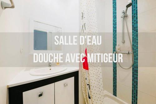 une salle de bain blanche avec un lavabo et une douche dans l'établissement Maison HyperCentre Les bons plans de Manu et Capu, à Dinard